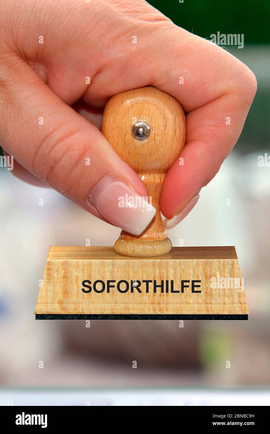 Stempel in der Hand einer Frau mit Schriftzug Soforthilfe, Soforthilfe, Deutschland Stockfoto