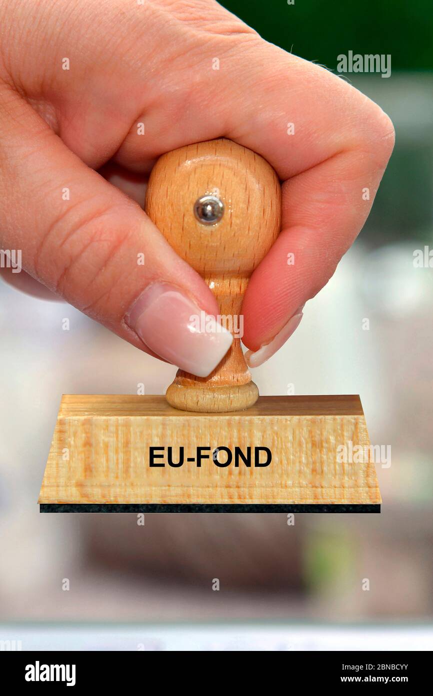 Stempel in der Hand einer Frau mit dem Schriftzug EU-Fond, EU-Hilfspaket Stockfoto