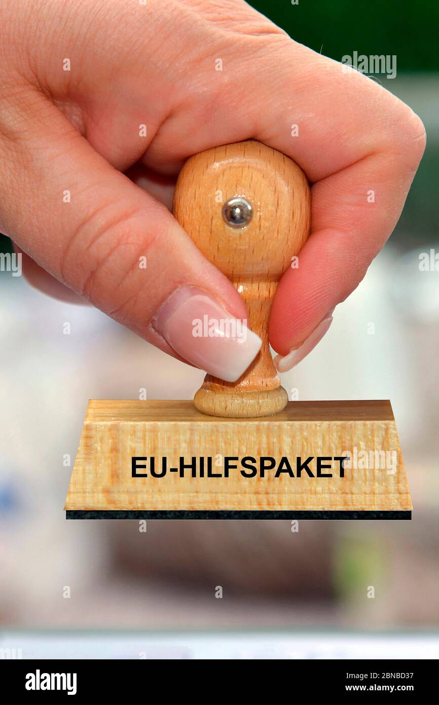 Stempel in der Hand einer Frau mit Schriftzug EU-Hilfspaket Stockfoto