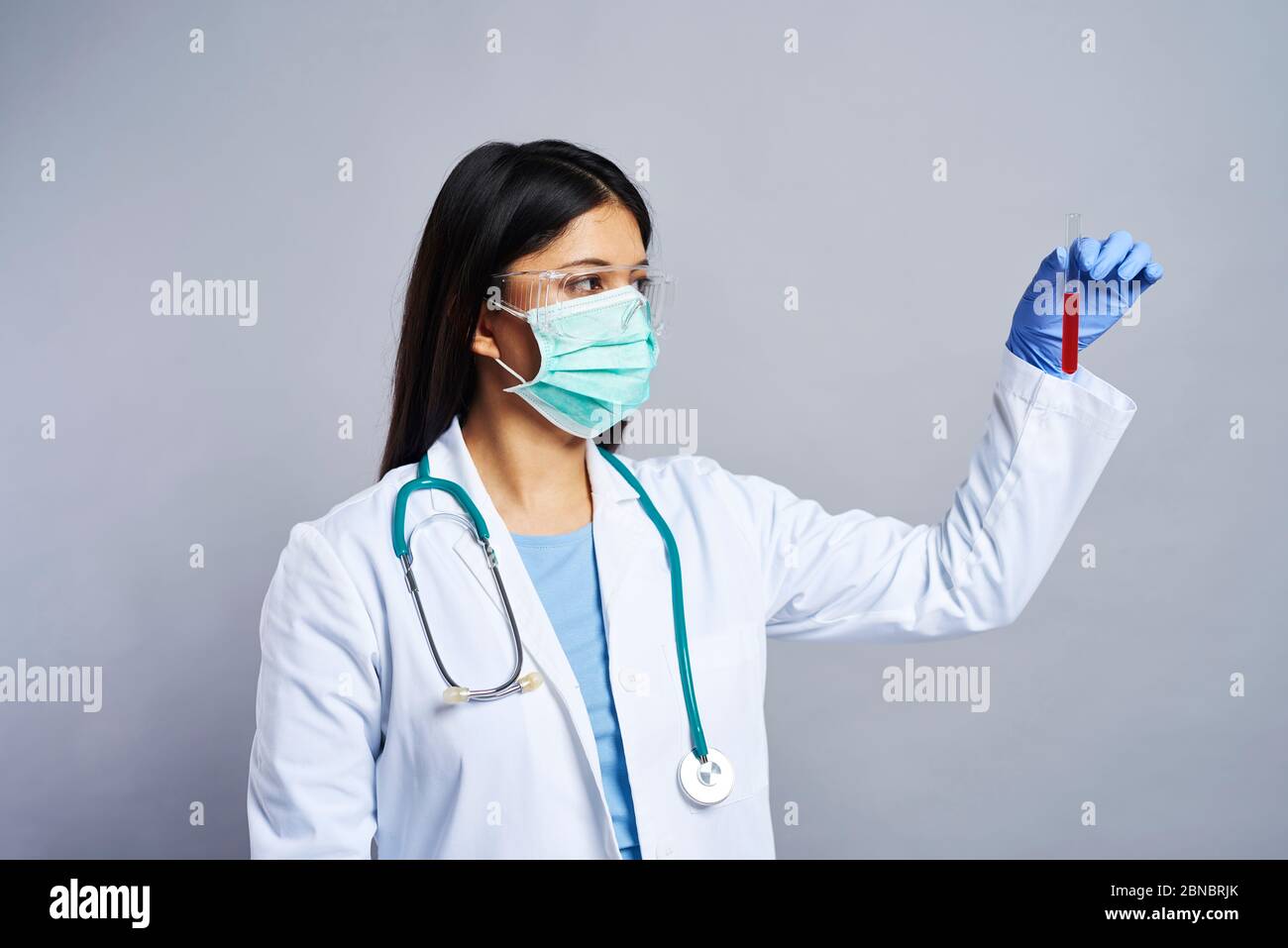 Arzt hält ein Reagenzglas mit Blut Stockfoto