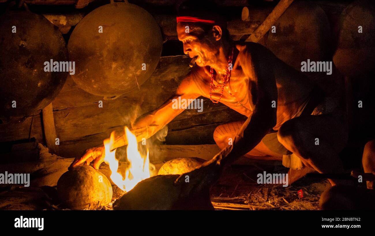 Erstaunliche Aufnahme eines Stammesmännchens, das Feuer zum Kochen macht Stockfoto