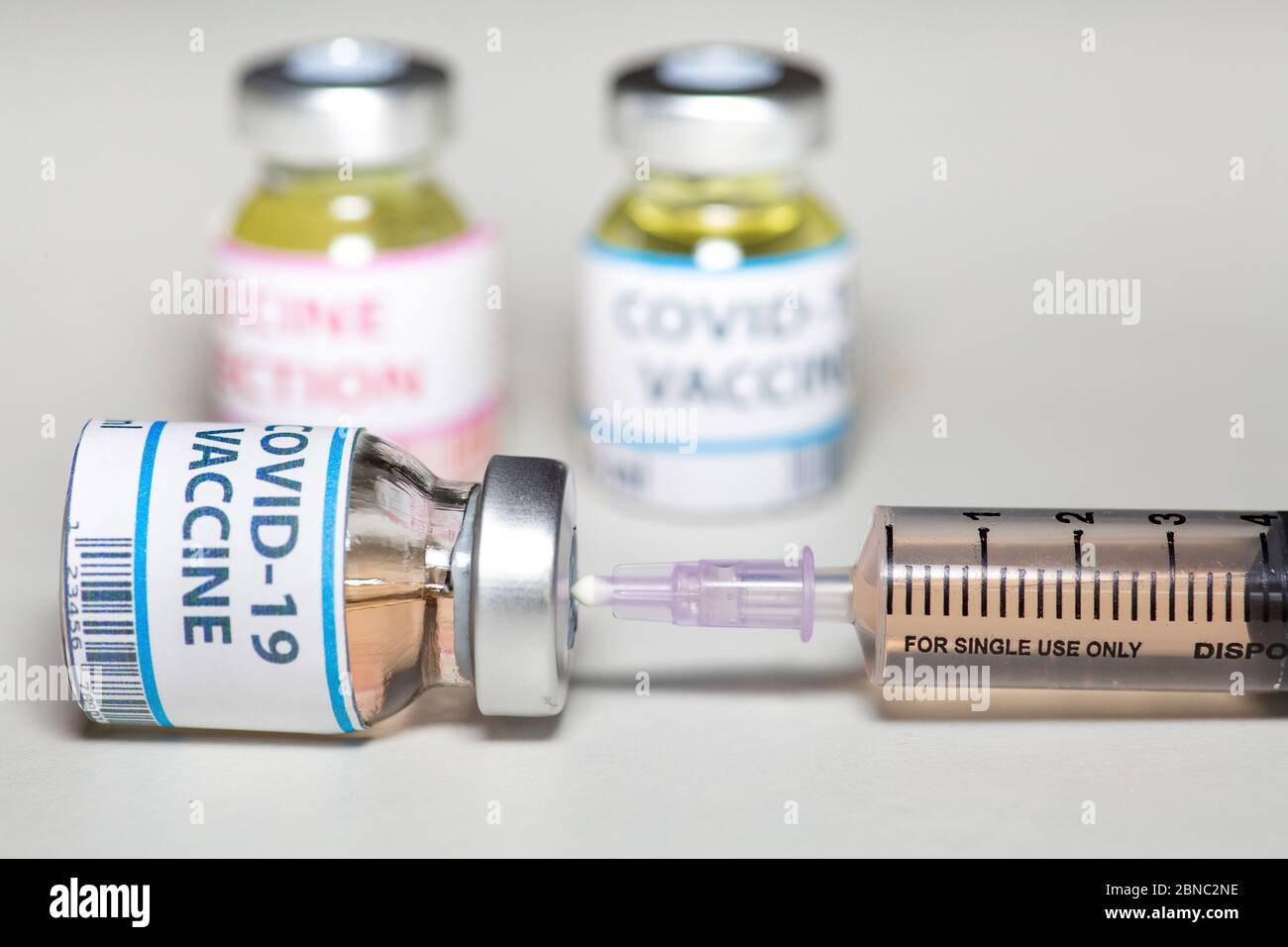Konzeptionelles Bild einer hypodermischen Nadel, die in eine Impfstoffflasche mit Medikamenten zur Behandlung von Coronavirus-Patienten eingesetzt wird Stockfoto