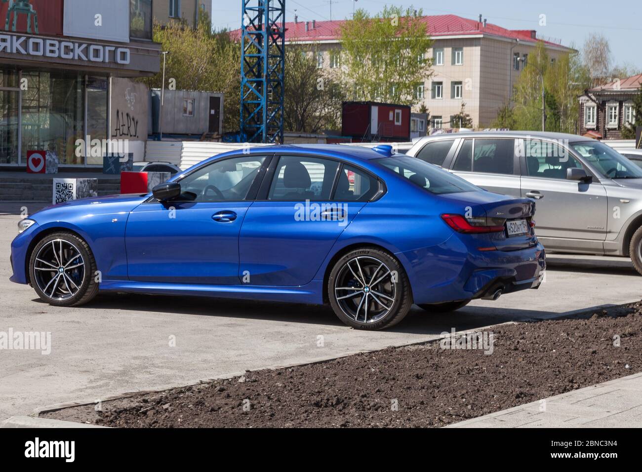 Novosibirsk, Russland - 04.26.2020: Der neue BMW 3er-Wagen in einem leuchtend blauen Metallic-Farbton vor dem Hintergrund einer urbanen russischen Landschaft. G Stockfoto