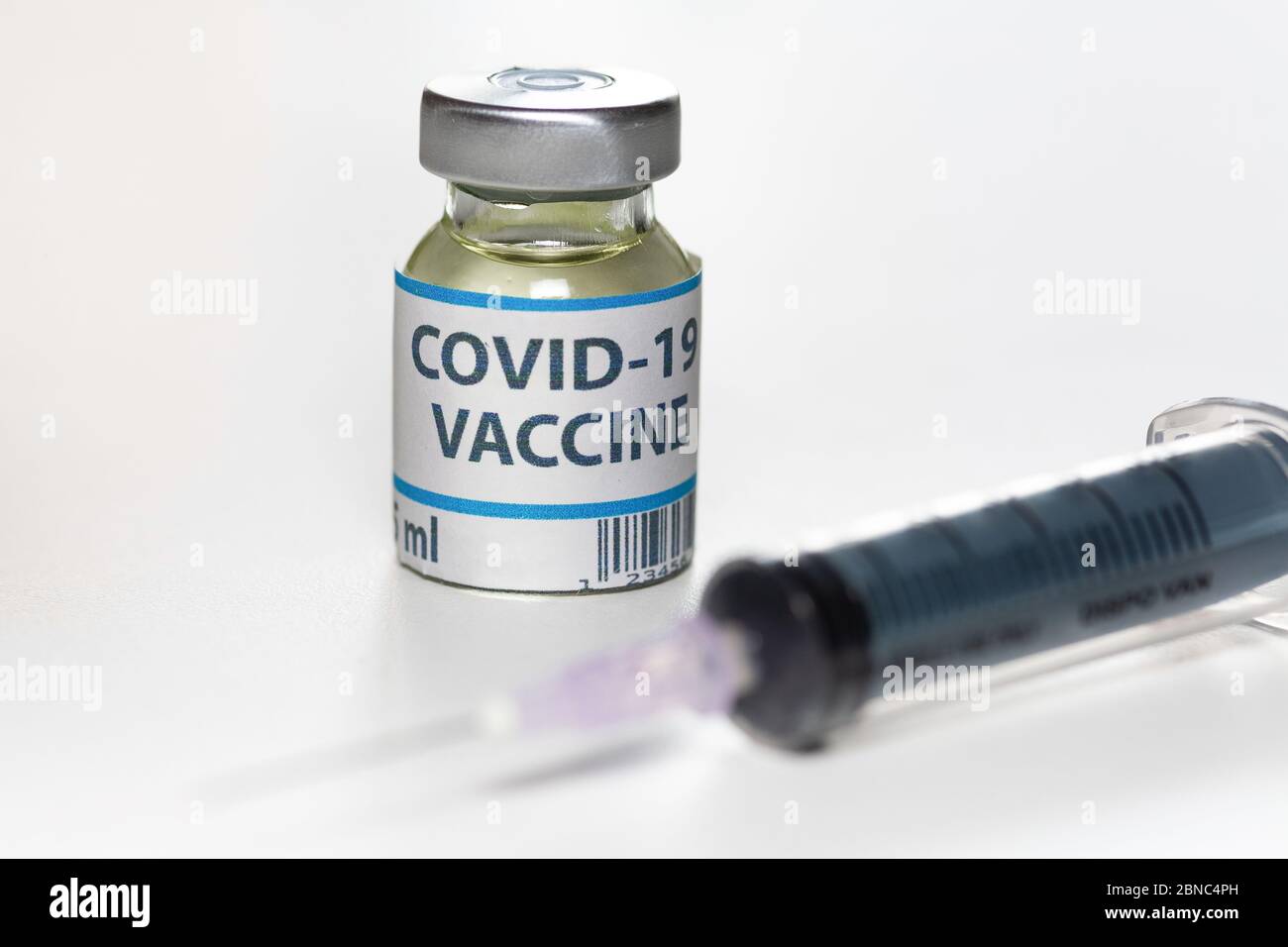 Coronavirus Impfstoffflaschen mit Injektionsspritze auf weißem Hintergrund, aufgenommen mit selektivem Fokus Stockfoto