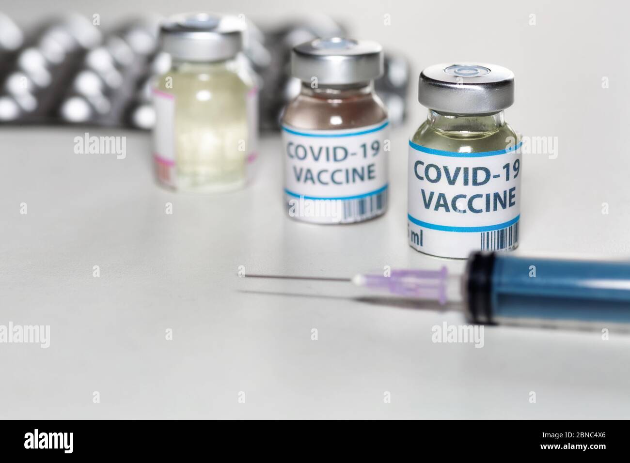 Injektionsspritze mit Impfstoffflaschen und Medikamenten in selektivem Fokus zur Behandlung von COVID-19 Coronavirus-Patienten Stockfoto
