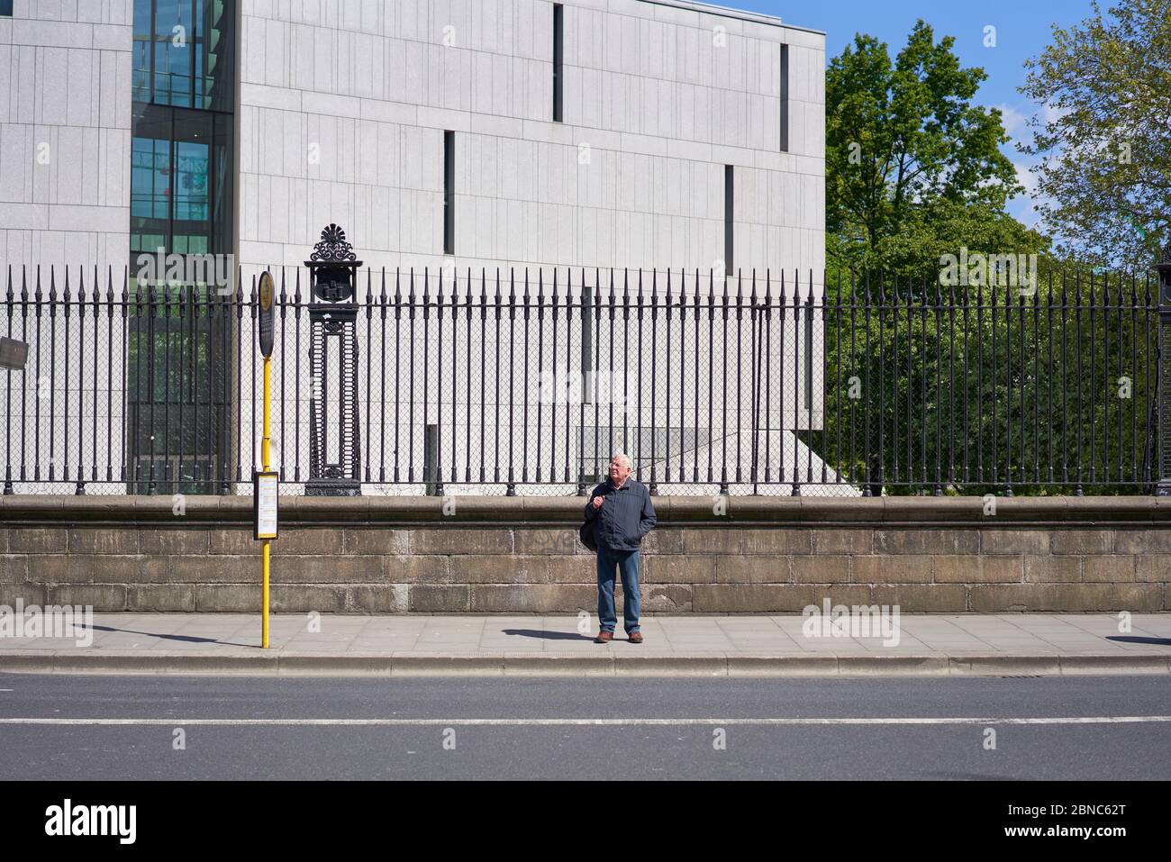 Ein Mann, der in Dublin auf einen Bus wartet. Stockfoto