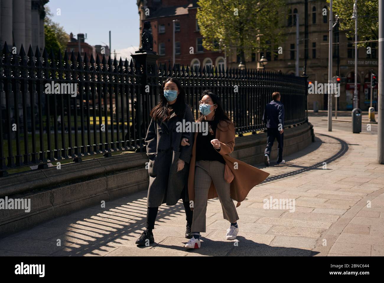 Zwei Frauen mit gesichtsmaske gehen am Trinity College Dublin während der weltweiten Coronavirus-Pandemie spazieren. Stockfoto