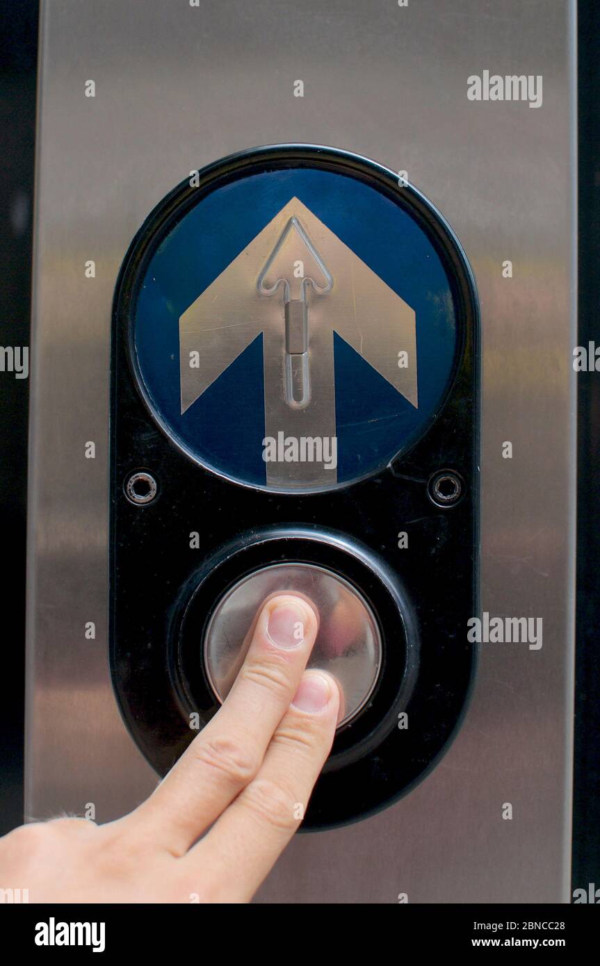 Finger drücken eine Ampel Taste in Brisbane. Dies kann als Konzepte für die Entscheidungsfindung, den Fortschritt oder die nächste Ebene verwendet werden Stockfoto