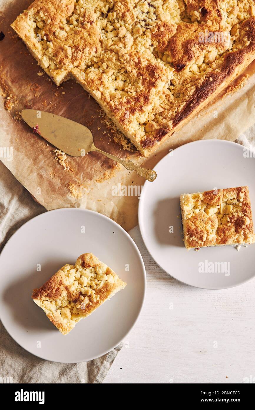 High-Angle Schuss von Stücken von köstlichen Jerry Crumble Sheet Kuchen auf einem weißen Holztisch Stockfoto