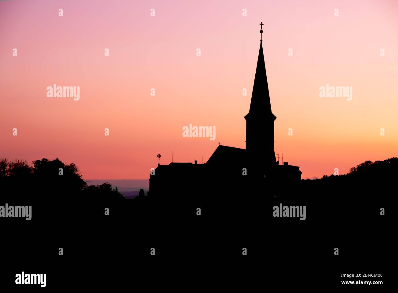 Silhouettenblick auf die orthodoxe Pfarrkirche am Abend in Gumpoldkirchen, einem berühmten Ort für ihren Wein und Heuriger als große Hangweinberge. Stockfoto
