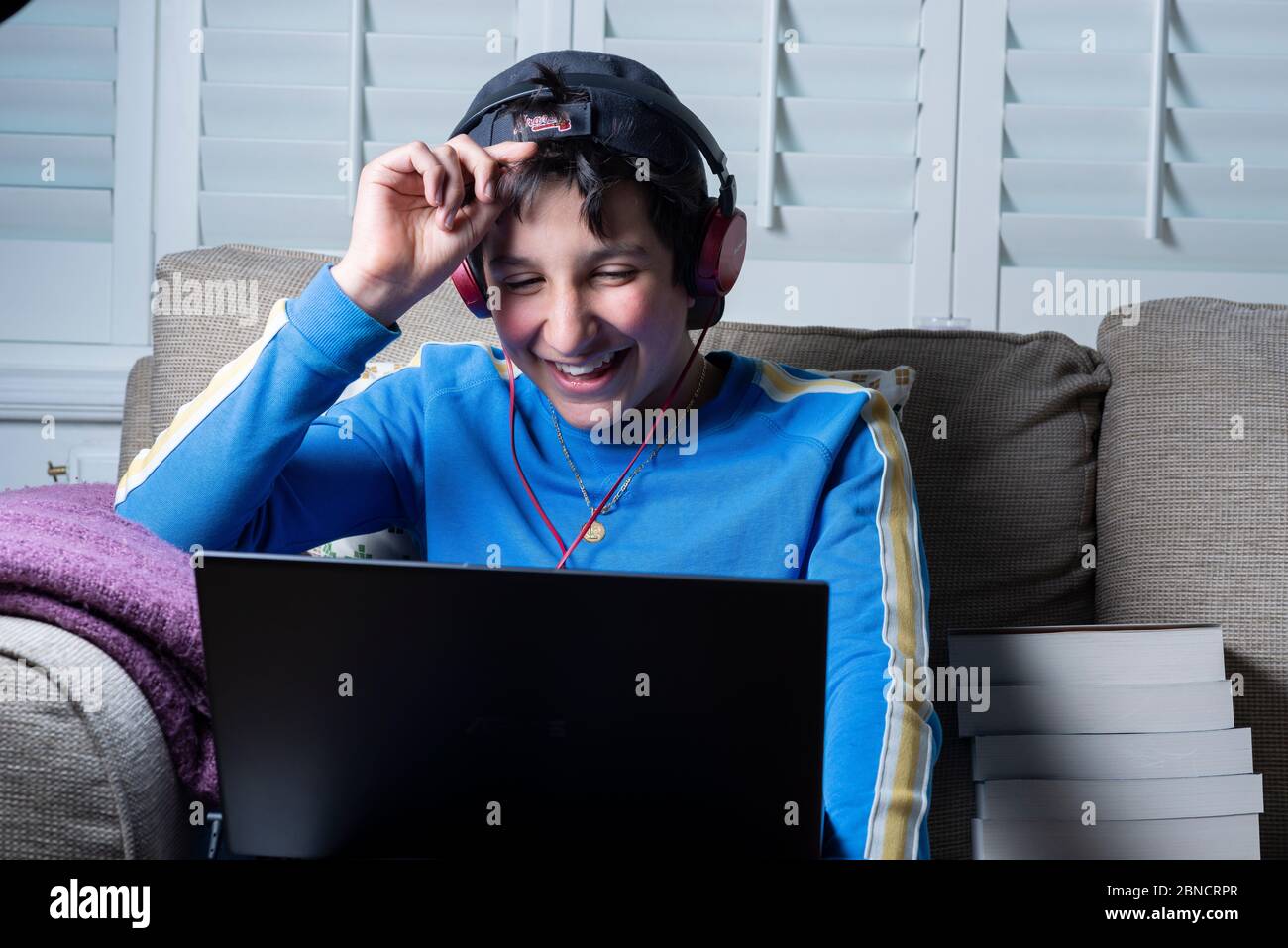 Teenager-Junge, 13, schaut lustige Videos online auf seinem Laptop, Großbritannien Stockfoto