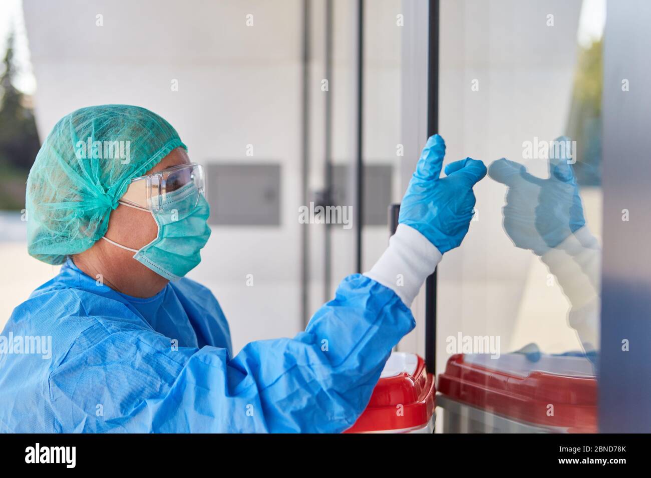 Arzt oder Chirurg während des Organtransports für die Operation vor der Klinik in Schutzkleidung gibt Anzeichen einer Aufnahme Stockfoto