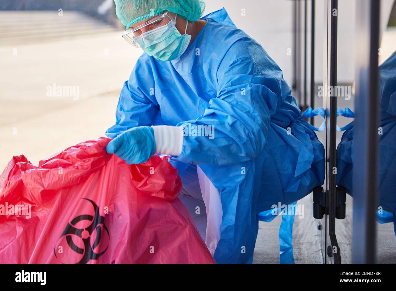 Reiniger, der die Entsorgung gefährlicher Abfälle während der Coronavirus-Pandemie in einer Klinik überprüft Stockfoto