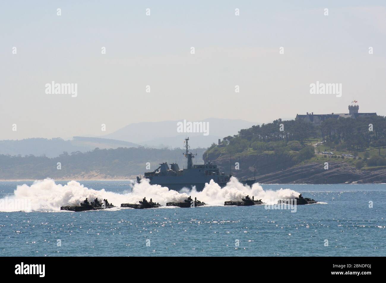 Serie 20 von 165 fünf amphibische Fahrzeuge AAV-7A mit Dampfwolken, die während des Tages der Streitkräfte an der Bergjägerin Sella (M32) und dem Palast Magdalena vorbeifahren Stockfoto