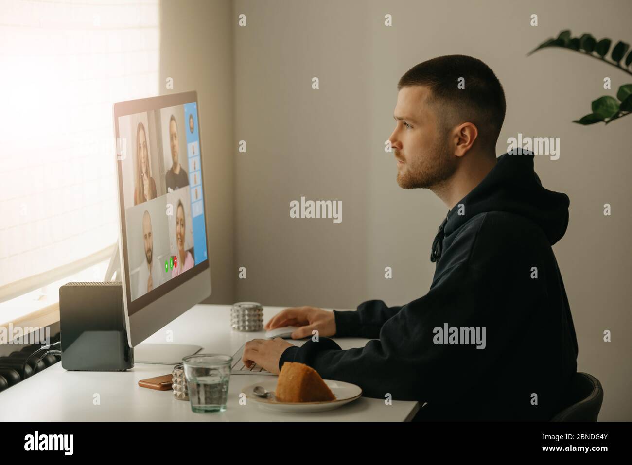 Ein Kollege, der intensiv von zu Hause aus an einer Online-Briefing arbeitet. Stockfoto