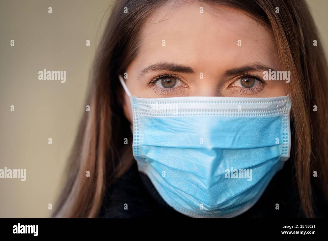Junge Frau trägt Einweg-blauen Virus Gesicht Mund Nase Maske, Nahaufnahme Porträt. Coronavirus Covid-19 Konzept zur Prävention von Ausbrüchen Stockfoto