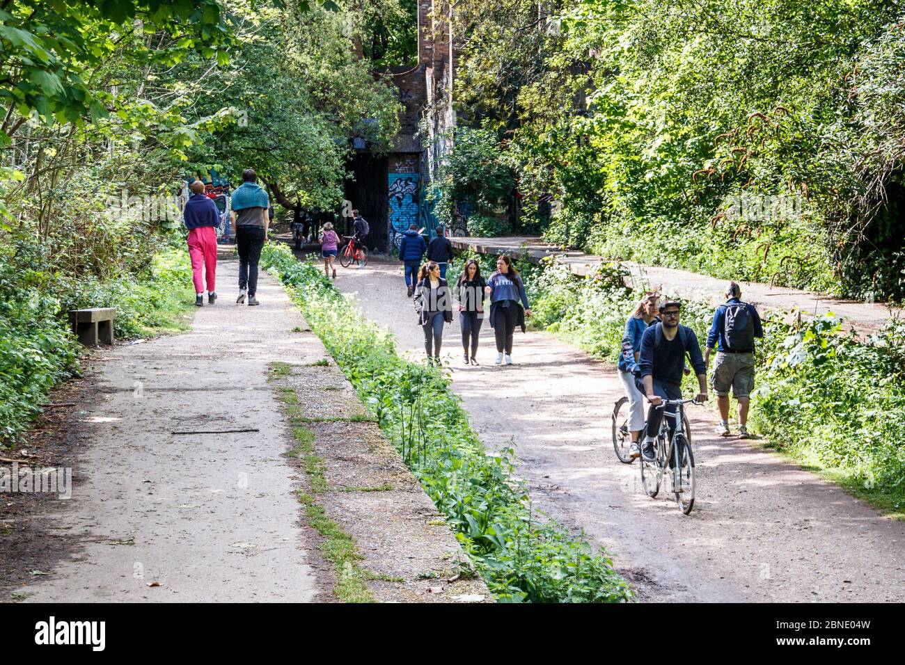 Wanderer, Jogger und Radfahrer, die das warme Wetter auf dem Parkland Walk in London, Großbritannien, genießen Stockfoto