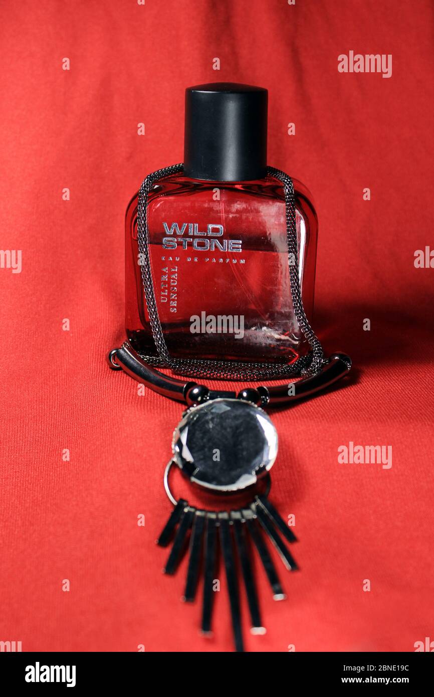 Rote Farbe Manner Parfum Flasche Auf Rotem Hintergrund Mit Weiblichen Accessoires Isoliert Rote Parfumflasche Von Wild Stone Mit Schwarzer Kappe Stockfotografie Alamy