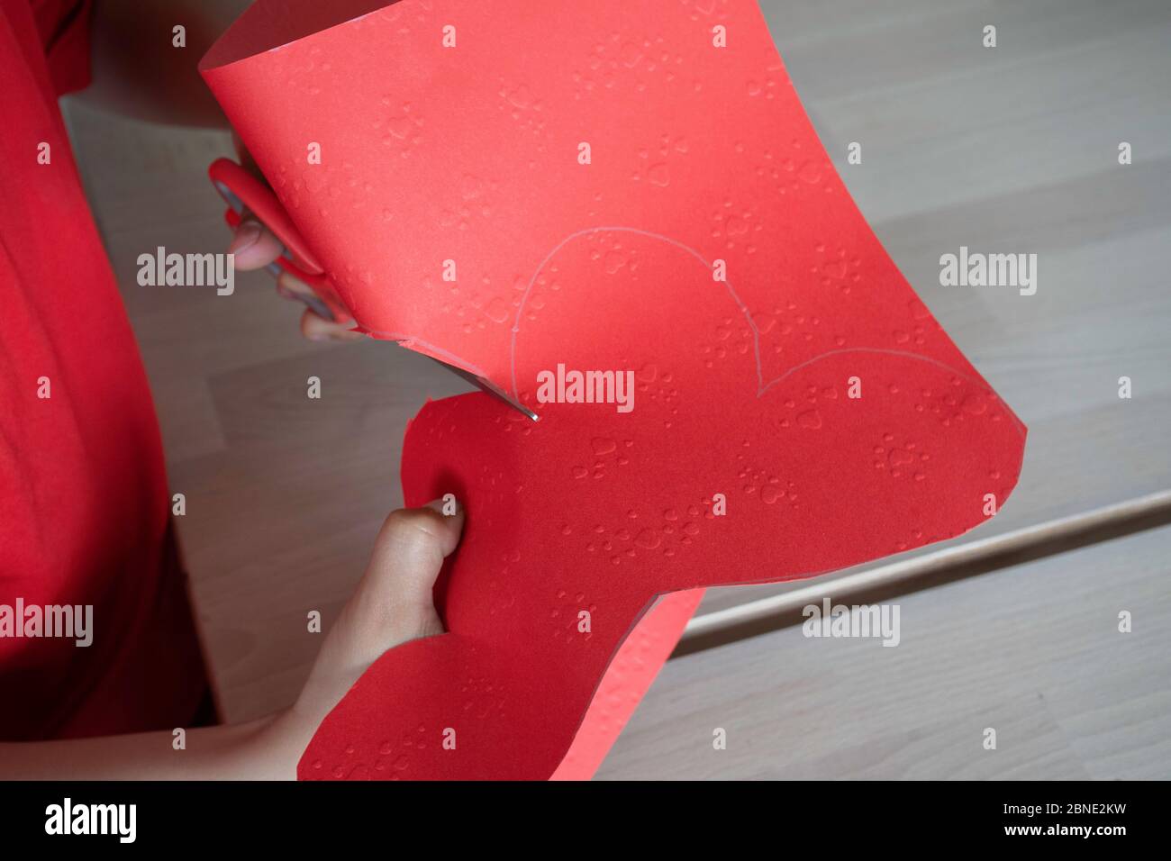 Kleiner Mann schneidet ein Herz - Geschenk für die Mutter Stockfoto