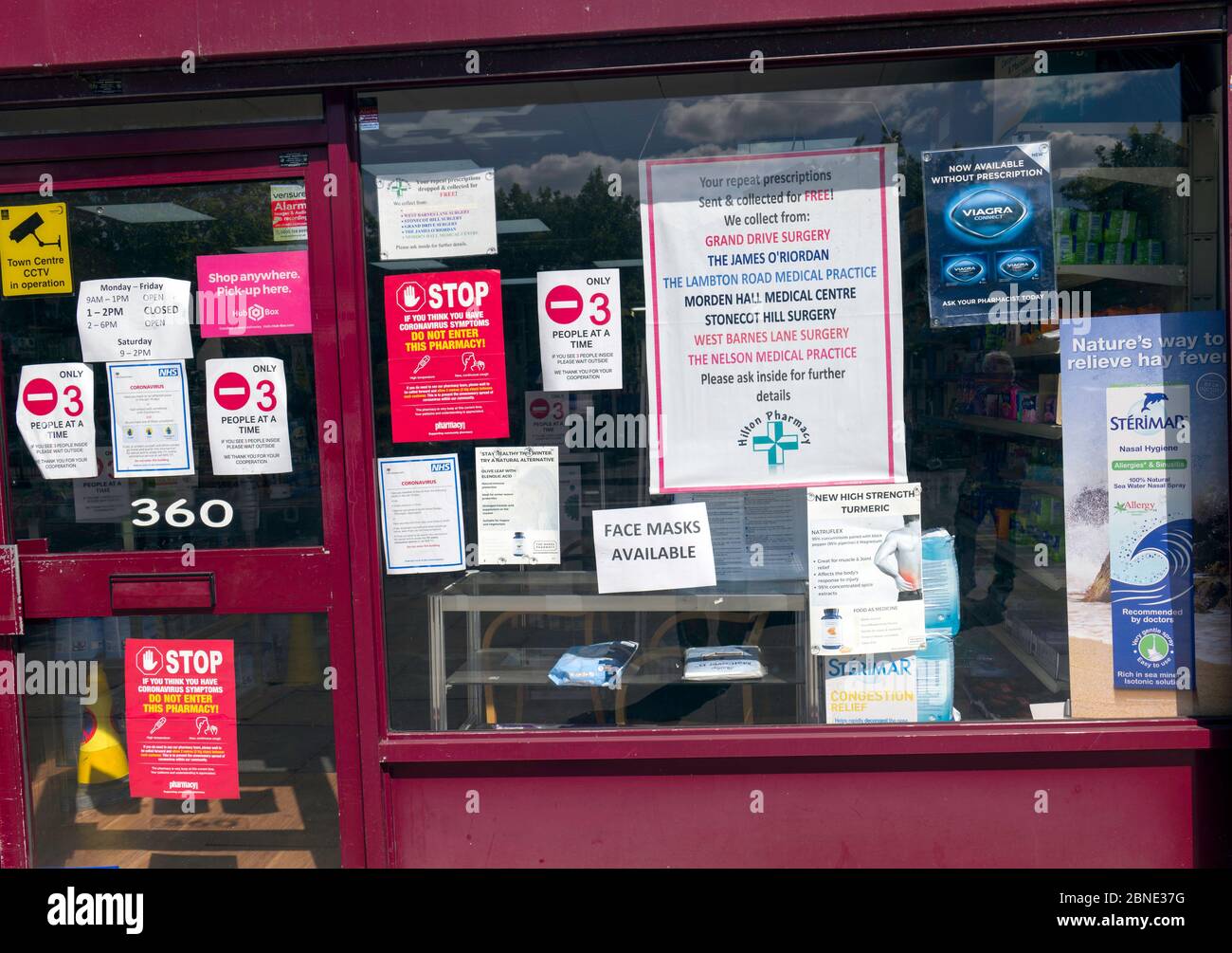 Apotheke mit mehreren Schildern, Plakaten, die Kunden über den Zugriff auf die Hilfe von Covid-19 informieren. Stockfoto