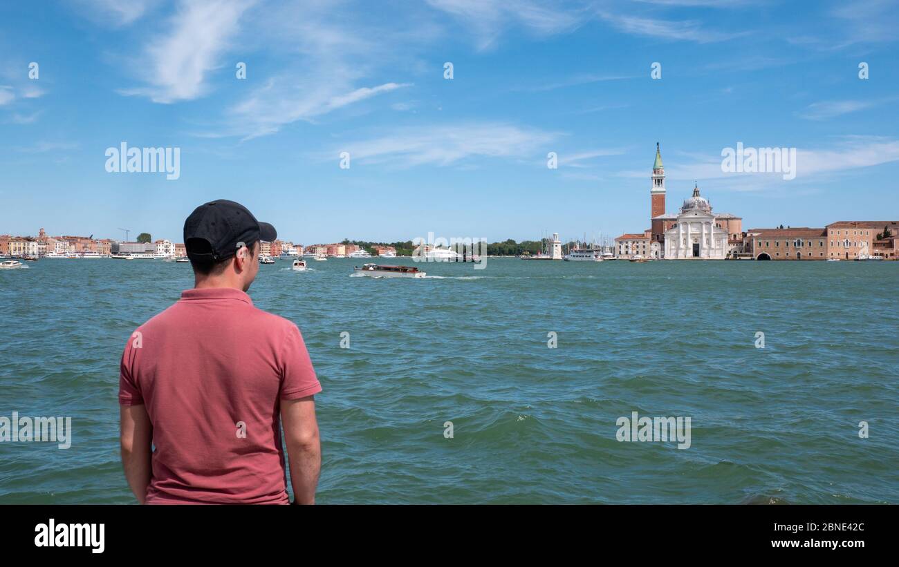 Venedig Italien 08 14 2019: Junger Mann, der die Kirche San Giorgio Maggiore beobachtet. Stockfoto