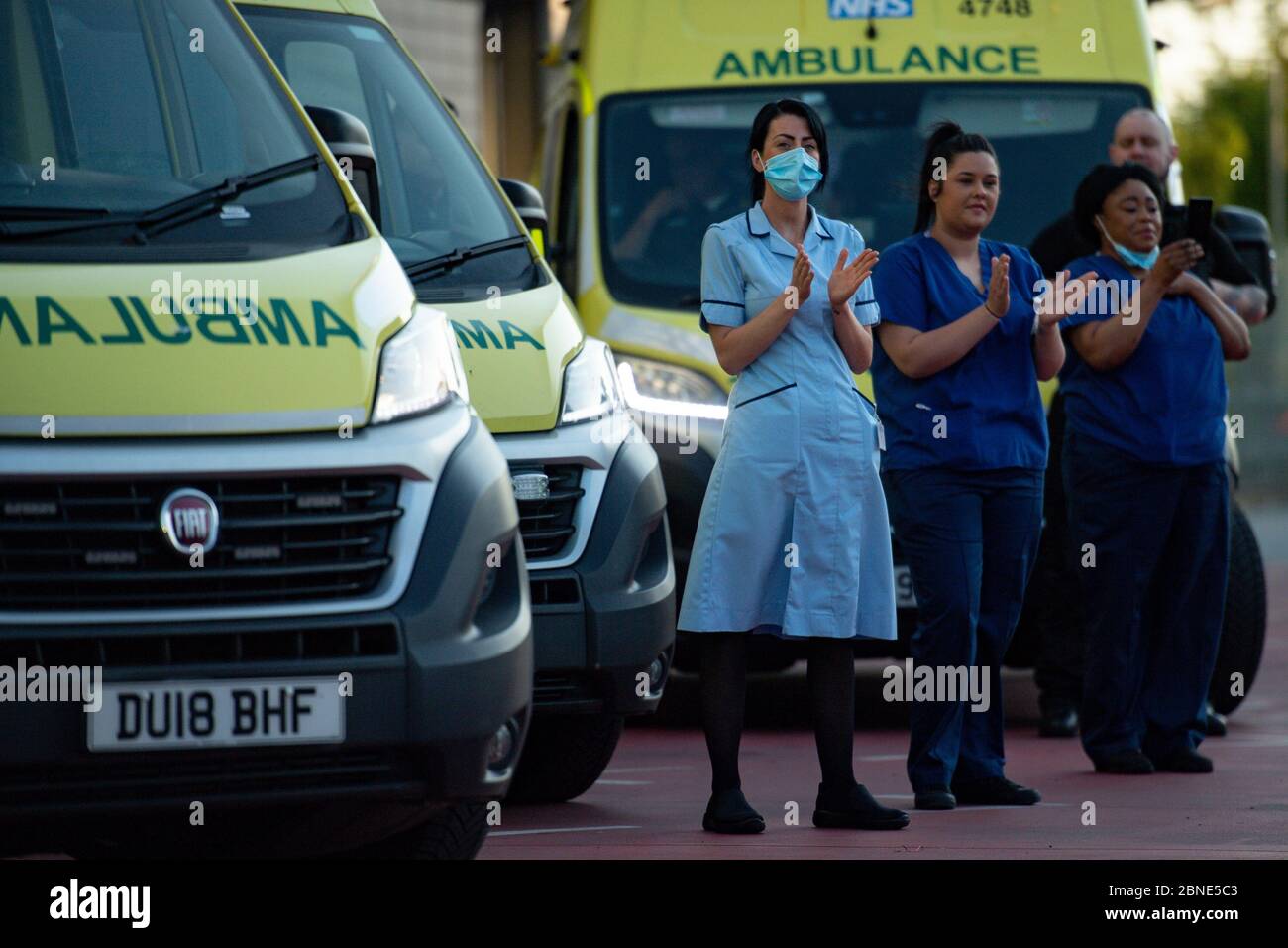 NHS-Mitarbeiter vor dem Queen Elizabeth Hospital in Birmingham, als sie sich dem Applaus anschließen, um lokale Helden während des landesweiten Clap für Betreuer zu begrüßen, um NHS-Mitarbeiter und Betreuer zu unterstützen, die gegen die Coronavirus-Pandemie kämpfen. Stockfoto