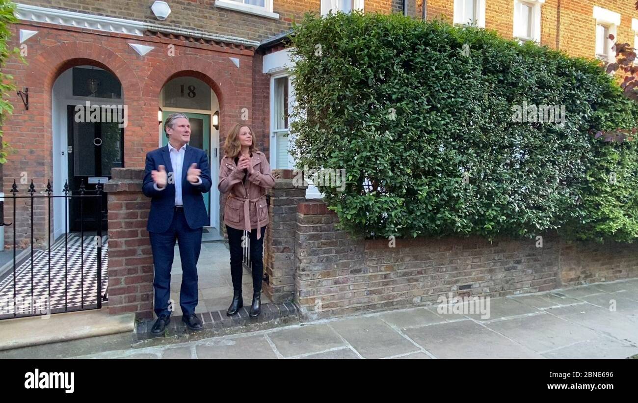 Bildschirmschnappung von Labour-Führer Sir Kier Starmer und seiner Frau Victoria vor ihrem Haus, als sie sich dem Applaus anschließen, um lokale Helden während des landesweiten Clap für Betreuer zu begrüßen, die NHS-Arbeiter und Pförter gegen die Coronavirus-Pandemie anerkennen und unterstützen. Stockfoto