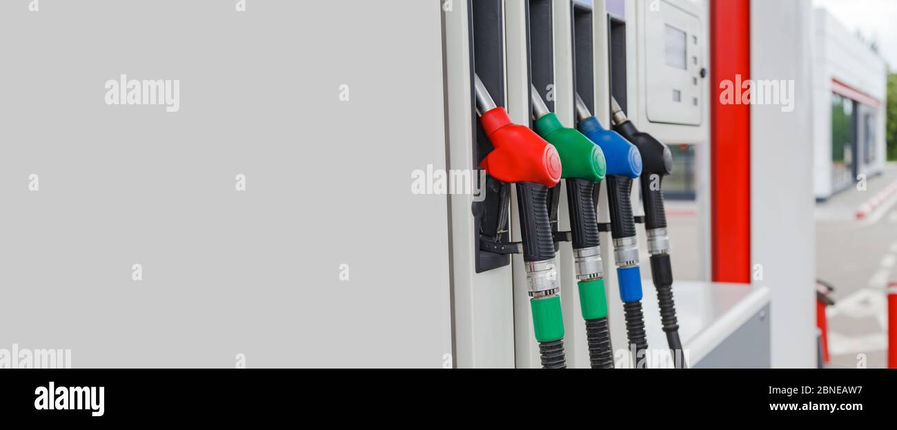 Virious farbige Tankpistolen oder Kraftstoffpistolen in der Kraftstoffsäule auf der Tankstelle mit Kopierraum. In den Nestern installierte Kraftstoffpistolen. Stockfoto