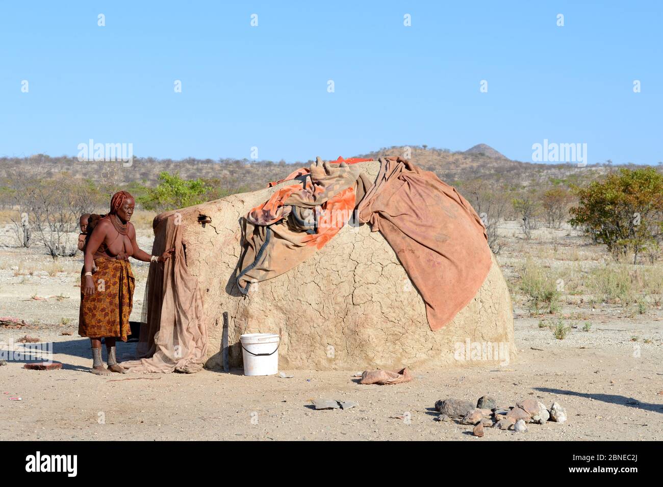 Himba Frau neben traditionellen Schlammhütte. Kaokoland, Namibia. Oktober 2015 Stockfoto