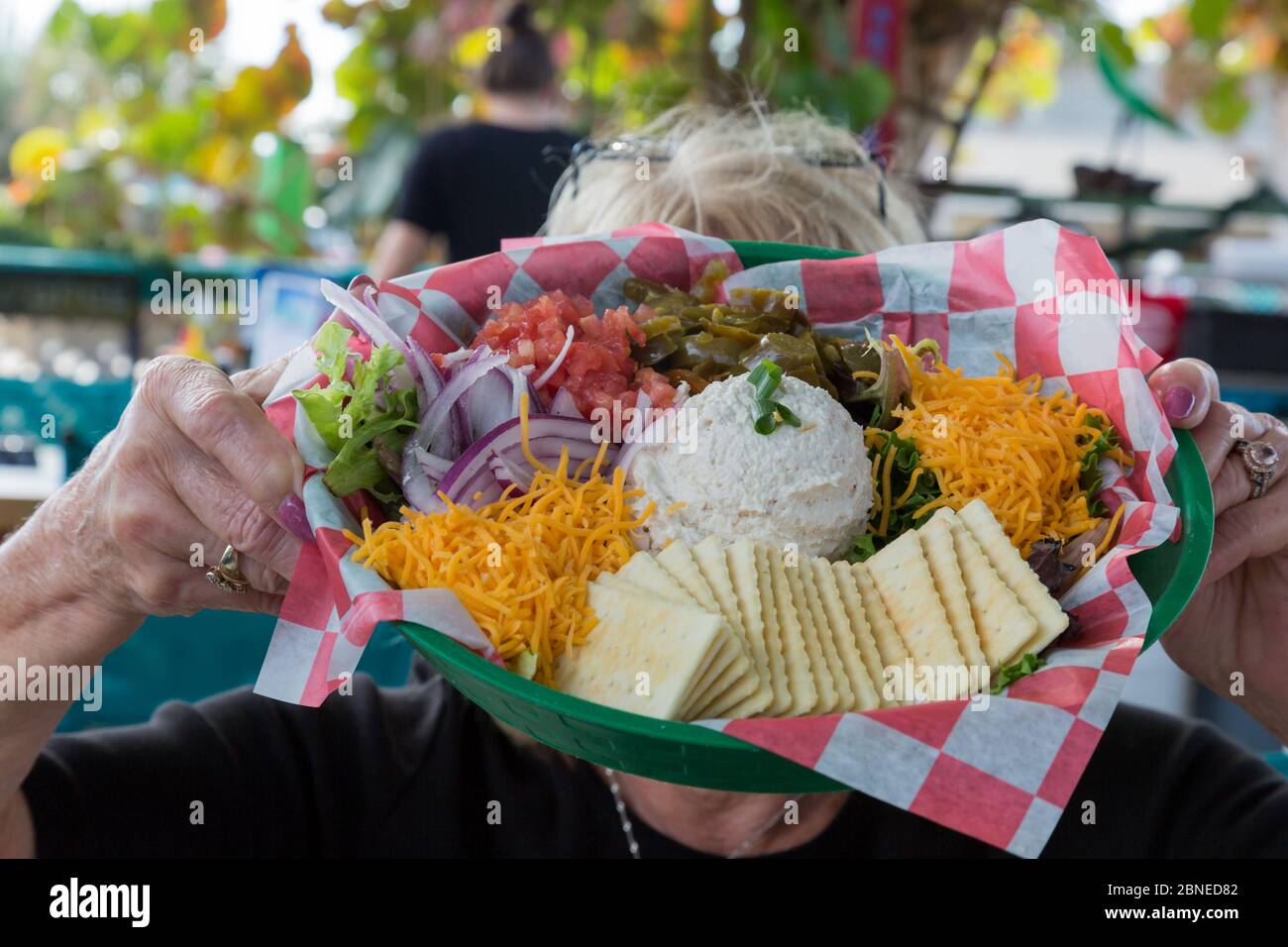 Eine Frau zeigt ihren farbenfrohen Simmerlin Fish Smak Vorspeisensammler im Restaurant Seabreeze von Archie in Fort Pierce, Florida, USA. Stockfoto