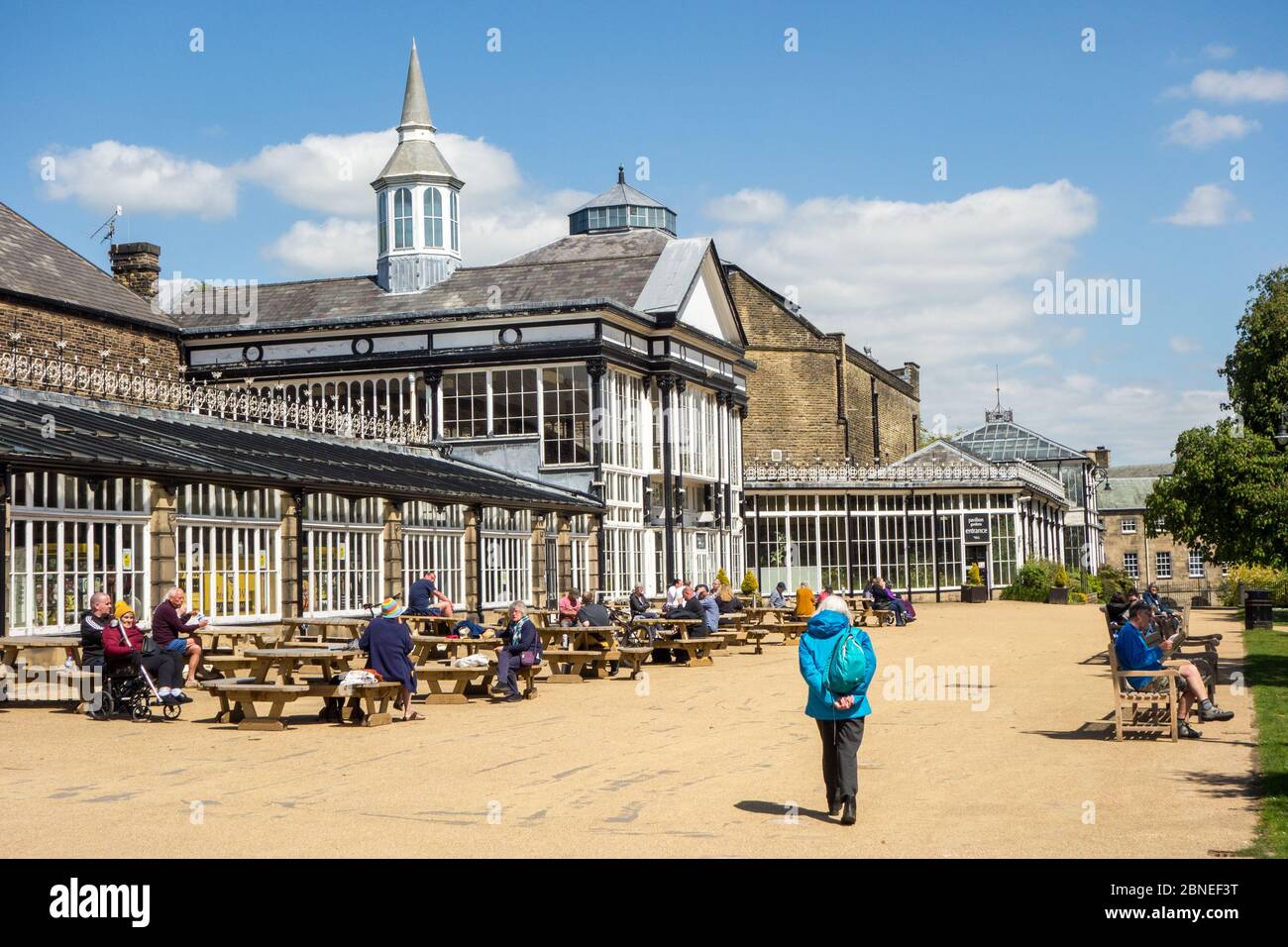 Leute, die draußen im Pavilion Gardens Buxton an einem sonnigen Tag essen und trinken Stockfoto