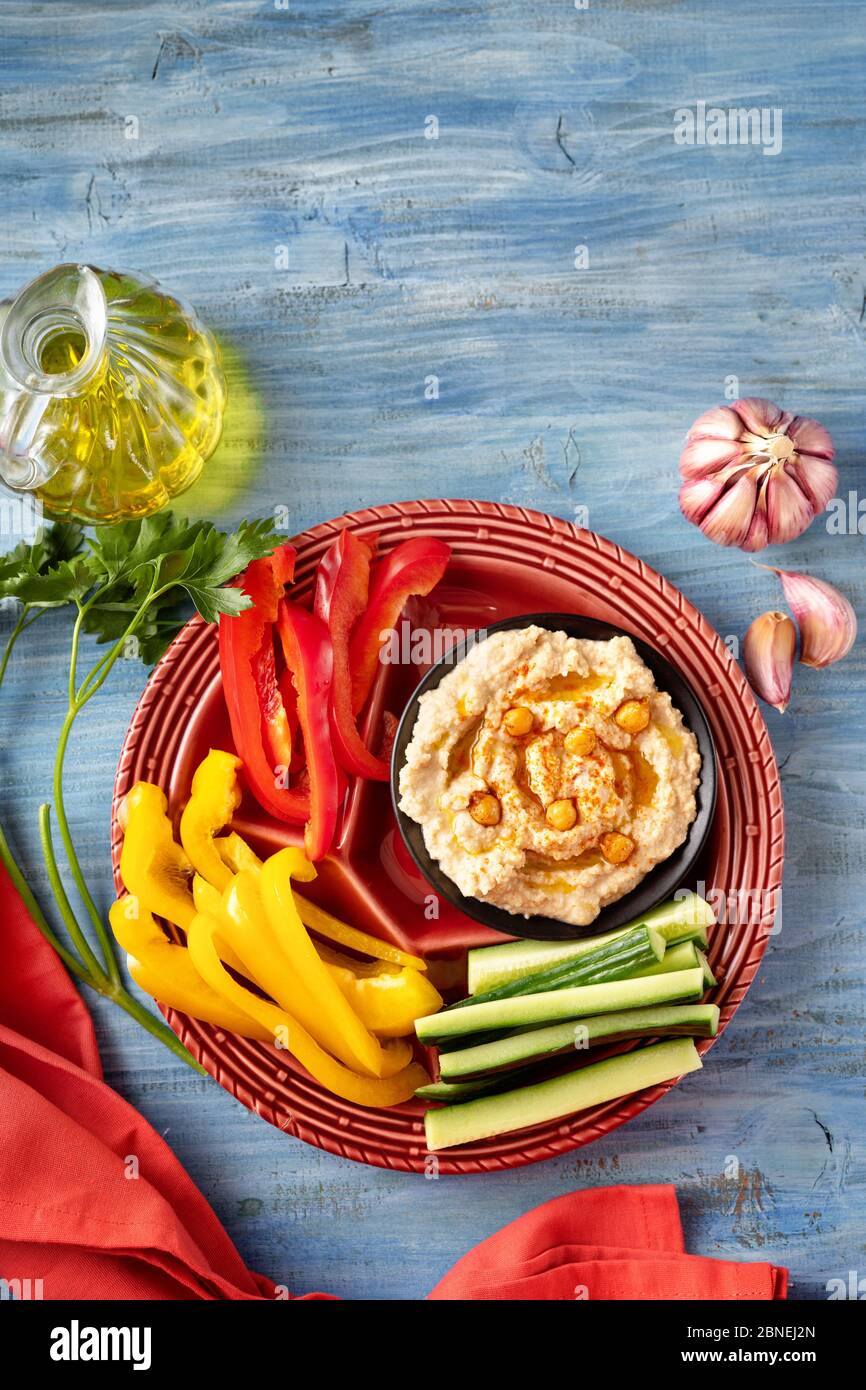 Draufsicht auf lebendige Platte mit verschiedenen frischen Gemüse mit Hummus Dip Stockfoto
