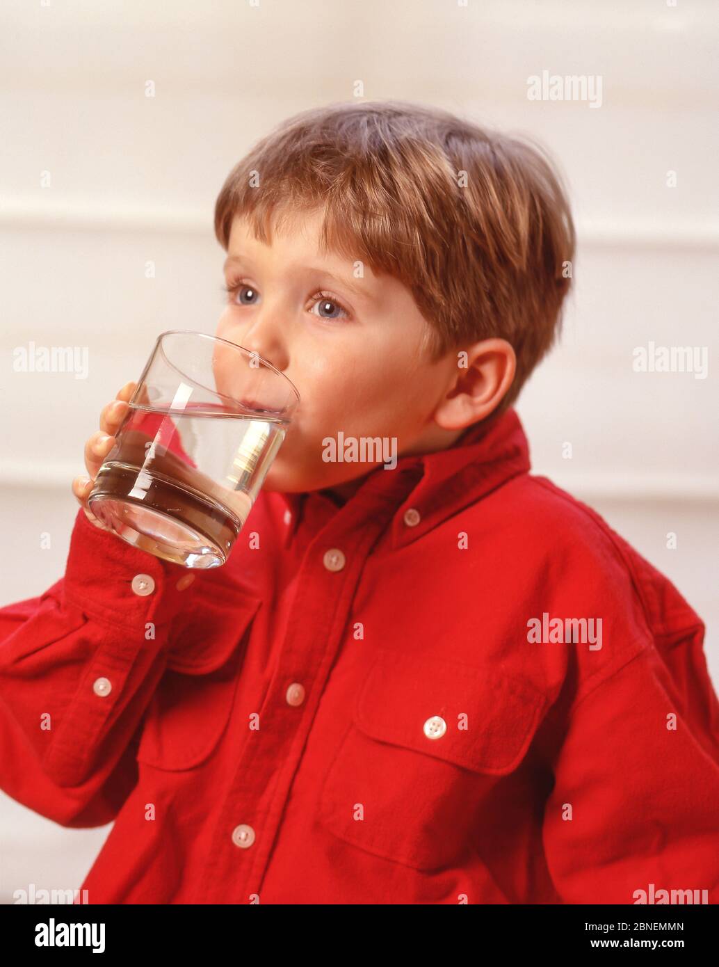 Kleiner Junge trinkt ein Glas Wasser, Winkfield, Berkshire, England, Vereinigtes Königreich Stockfoto