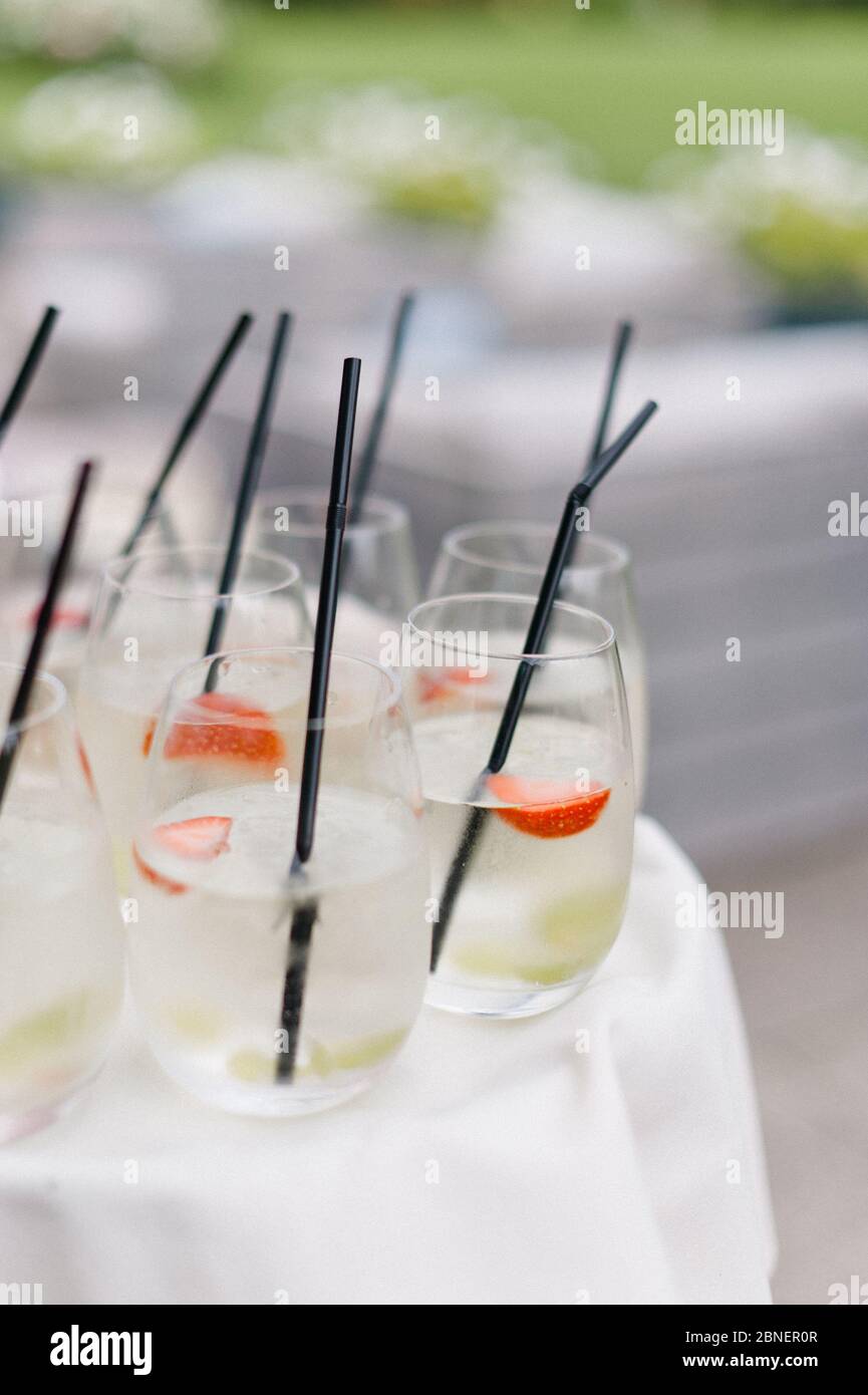 Eiskalte Holunderblüten-Cocktail-Drinks mit schwarzen Strohhalmen auf weißem Tischtuch Stockfoto