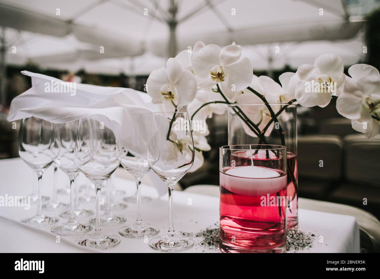 Foto eines leeren Weinglases neben einer Blumenvase Stockfoto