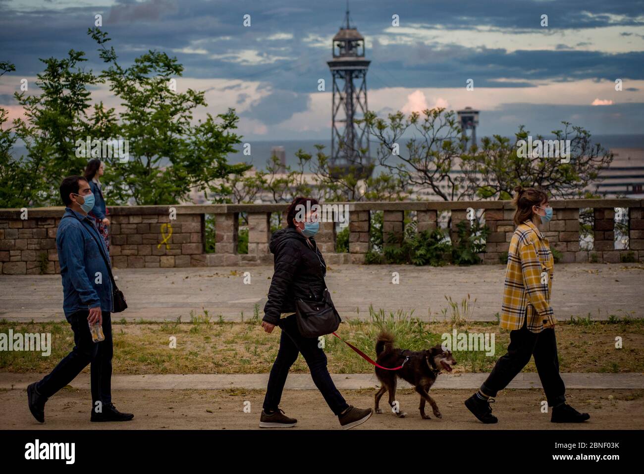 Menschen gehen mit Gesichtsmasken und üben soziale Distanz in den Montjuic Gärten in Barcelona. Stockfoto