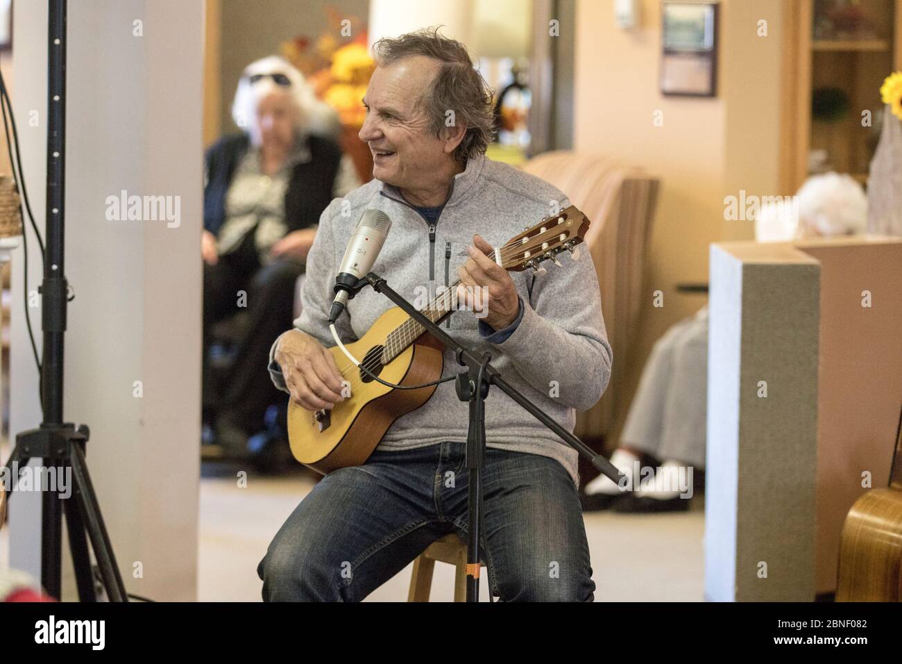 Foto von älteren männlichen, spielen Gitarrensang und Gesang, scheint Spaß zu haben. Stockfoto