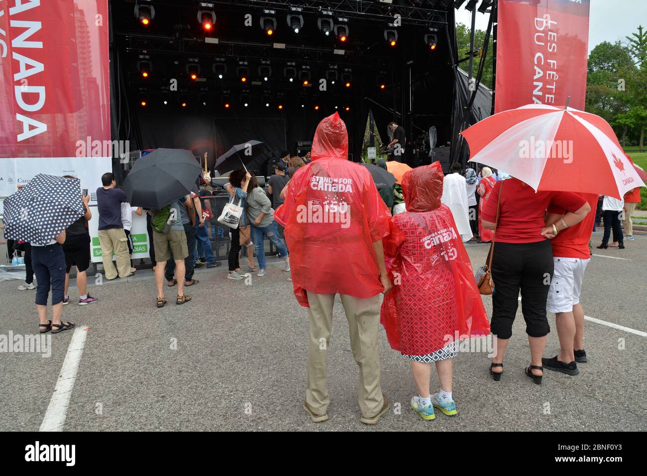 Die Menschen versammeln sich bei regnerischem Wetter im Thomson Memorial Park in Toronto, um die Vorstellungen des Canada Day zu beobachten. Stockfoto