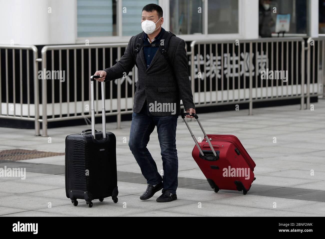 Passagiere mit Gesichtsmaske, die sich darauf vorbereiten, die Züge in andere Städte zu nehmen und die in der Stadt ankommen, werden am Platz vor dem Bahnhof WUH gesehen Stockfoto