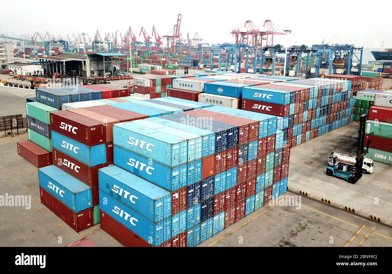 Lastwagen laden Container auf Schiffen, die Waren in einem Hafen in Lianyungang, Provinz Jiangsu, im Osten Chinas, nach Übersee exportieren, am 14. April 2020 Stockfoto