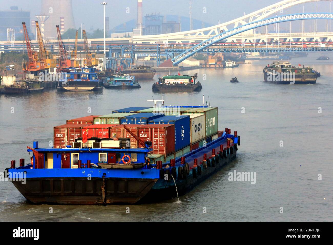 Schiffe, die Container und Güter transportieren, bewegen sich langsam auf dem Canale Grande, dem längsten und ältesten Kanal oder künstlichen Fluss der Welt, um zu deliv Stockfoto