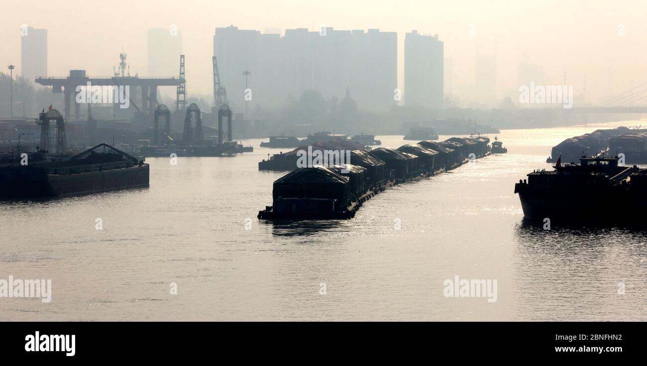 Schiffe, die Container und Güter transportieren, bewegen sich langsam auf dem Canale Grande, dem längsten und ältesten Kanal oder künstlichen Fluss der Welt, um zu deliv Stockfoto
