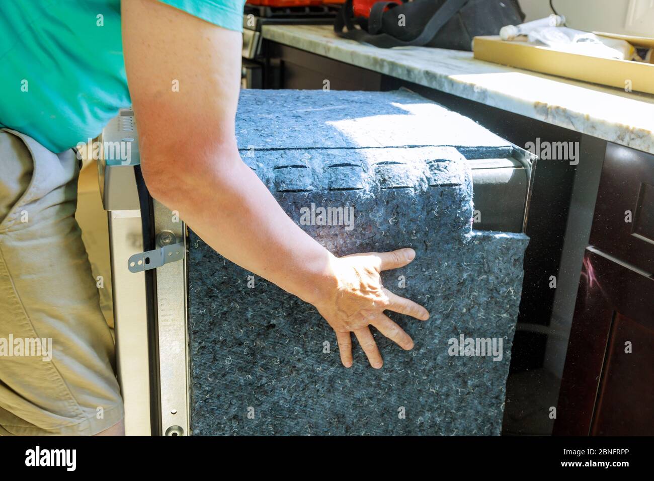 Handwerker, um Platz in der Spülmaschine Maschine in der Küche zu installieren Stockfoto