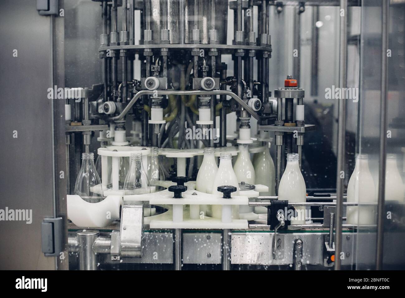 Graustufenaufnahme einer Milchabfüllmaschine in einer Fabrik Stockfoto