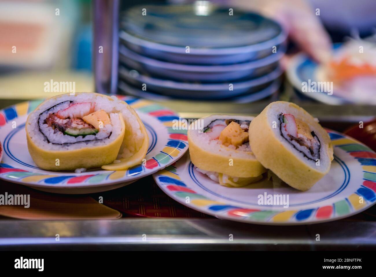 Sushi auf Förderband in einem japanischen Restaurant. Traditionelle japanische Küche von Kaitenzushi. Shushi Go Round ist eine berühmte Form des Fast Food in Asien, auch bekannt Stockfoto