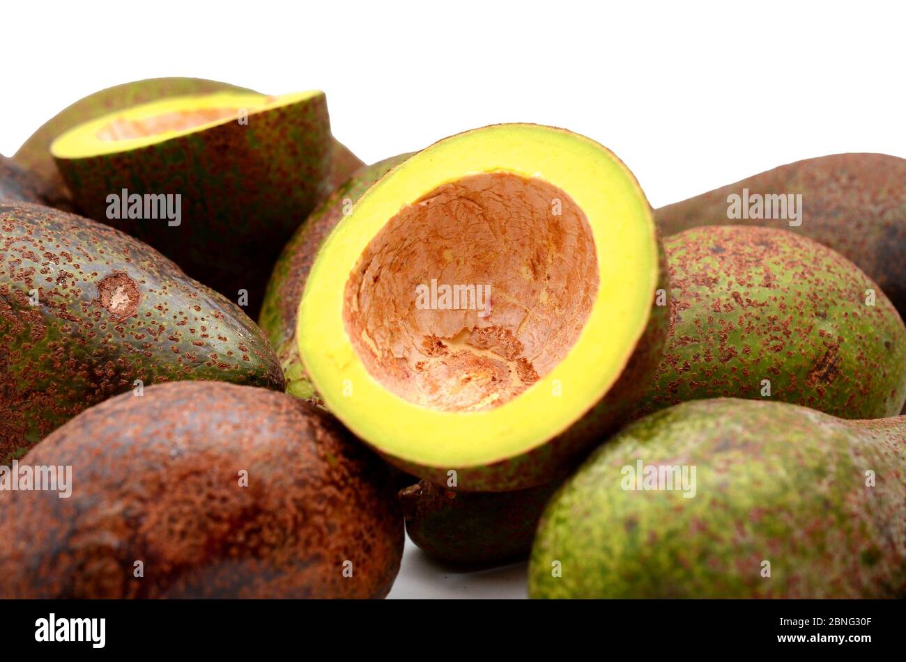 Frische Avocados zwei ganze und eine halbierte isoliert auf weiß Stockfoto