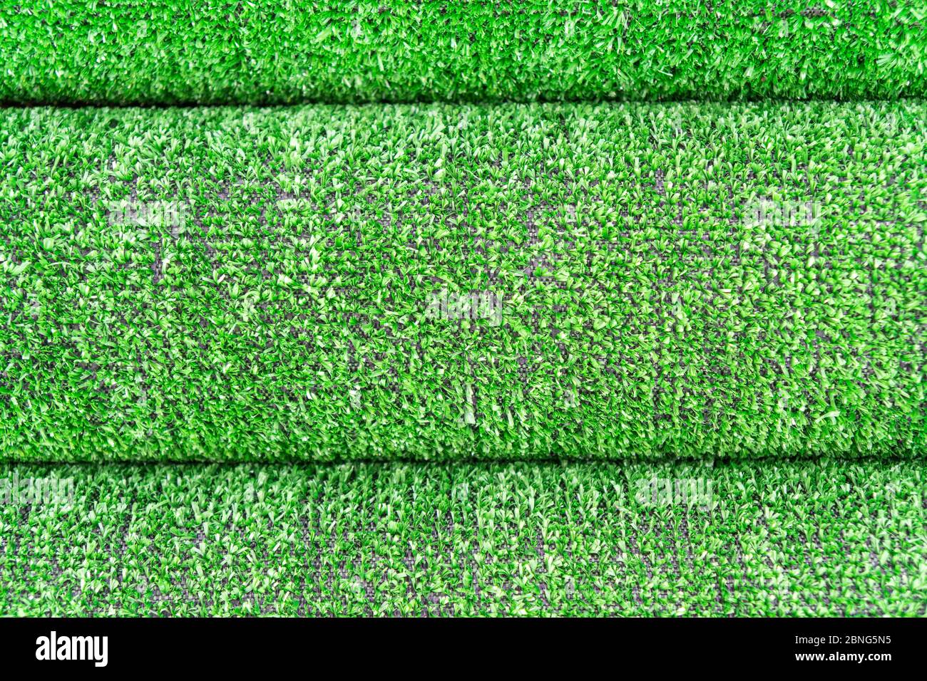 Kunstrasen Rasen Textur. Künstlicher Turf Hintergrund. Grünenering mit einem Kunstrasen. Rolled Kunstrasen Verlegung Hintergrund Textur. Rolle Stockfoto