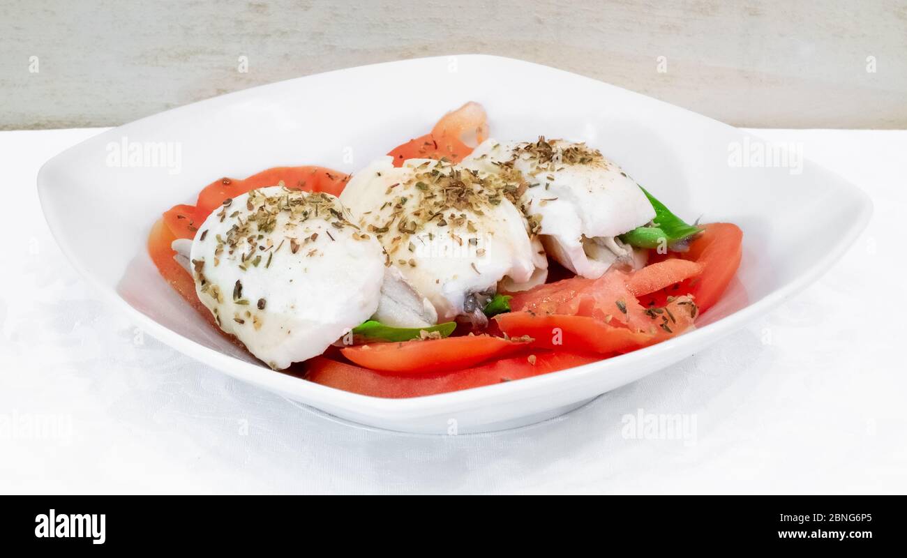 Caprese-Salat mit marinierten Sardinen. Zutaten: Tomaten, Mozzarella, marinierte Sardinen, Basilikum und Origan. Stockfoto