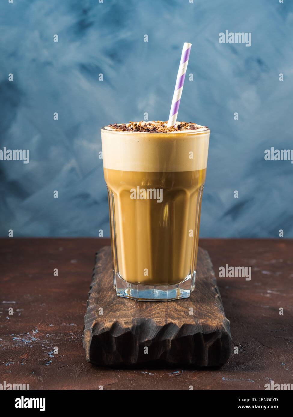 Frappe Kaffee in hohem Glas auf blau und braun Stockfotografie
