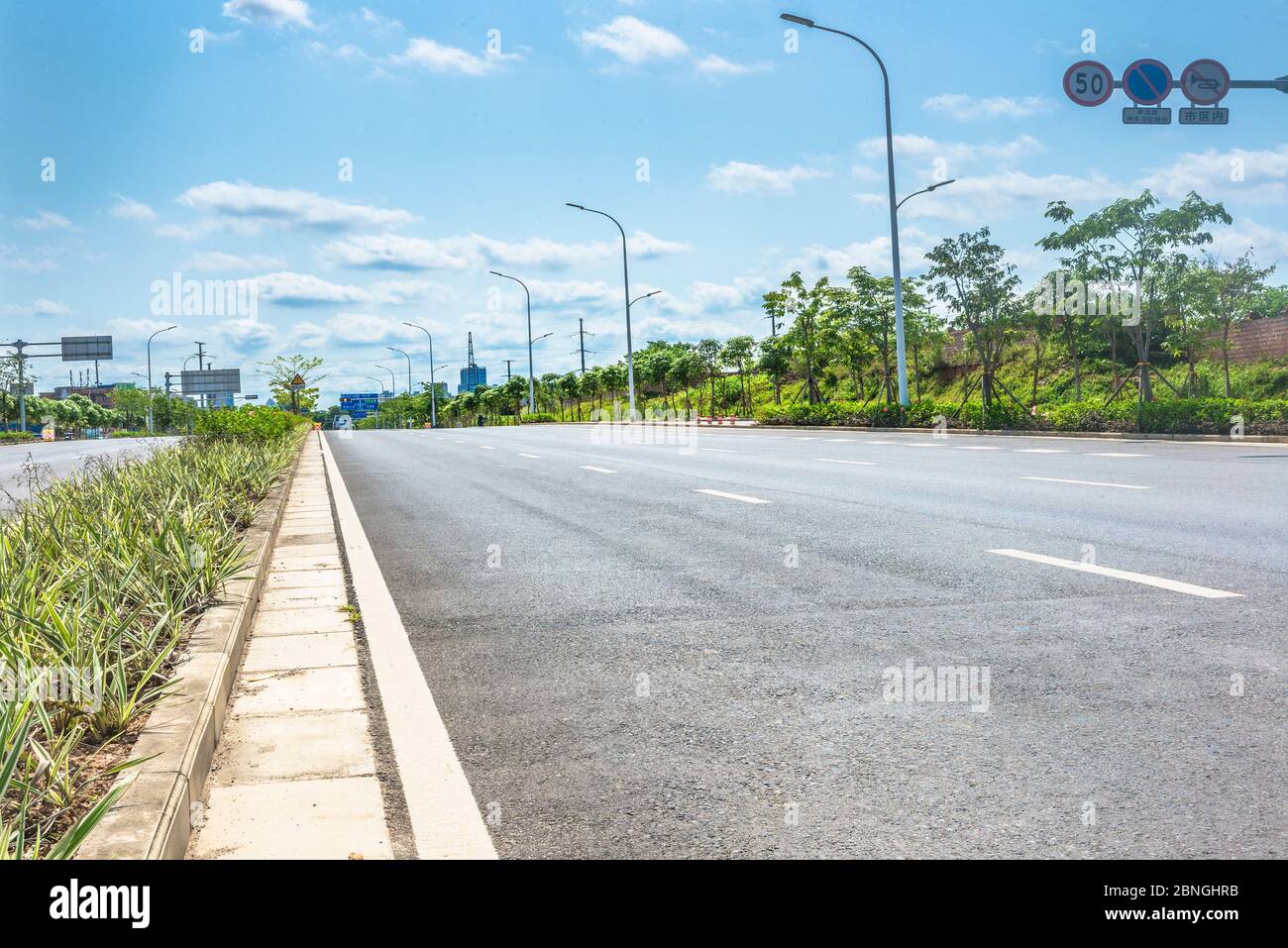 Unter dem blauen Himmel gibt es keine Asphaltstraße am Stadtrand. Stockfoto